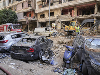 Rescuers sift through the rubble at the scene of an Israeli strike that targets Beirut's southern suburbs, as search and rescue operations c...