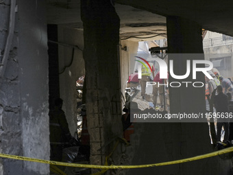 Rescuers sift through the rubble at the scene of an Israeli strike that targets Beirut's southern suburbs, as search and rescue operations c...