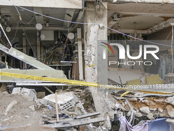 Rescuers sift through the rubble at the scene of an Israeli strike that targets Beirut's southern suburbs, as search and rescue operations c...