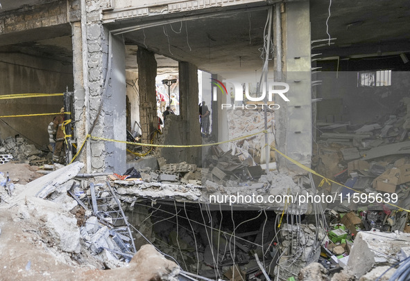 Rescuers sift through the rubble at the scene of an Israeli strike that targets Beirut's southern suburbs, as search and rescue operations c...