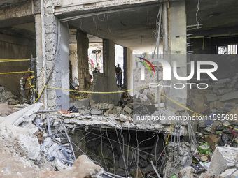 Rescuers sift through the rubble at the scene of an Israeli strike that targets Beirut's southern suburbs, as search and rescue operations c...