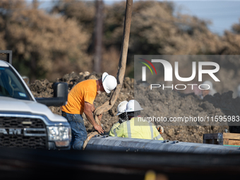 Workers repair a damaged liquefied gas pipeline following an explosion earlier in the week in La Porte, near Houston, Texas, on September 21...