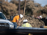 Workers repair a damaged liquefied gas pipeline following an explosion earlier in the week in La Porte, near Houston, Texas, on September 21...