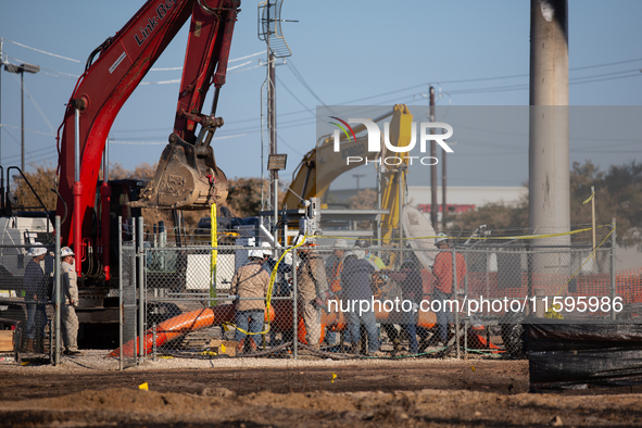 Workers repair a damaged liquefied gas pipeline following an explosion earlier in the week in La Porte, near Houston, Texas, on September 21...