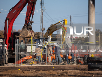 Workers repair a damaged liquefied gas pipeline following an explosion earlier in the week in La Porte, near Houston, Texas, on September 21...