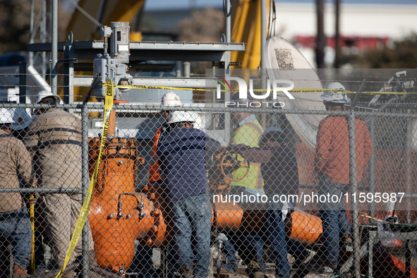 Workers repair a damaged liquefied gas pipeline following an explosion earlier in the week in La Porte, near Houston, Texas, on September 21...