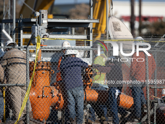 Workers repair a damaged liquefied gas pipeline following an explosion earlier in the week in La Porte, near Houston, Texas, on September 21...