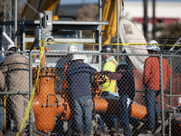 Workers repair a damaged liquefied gas pipeline following an explosion earlier in the week in La Porte, near Houston, Texas, on September 21...