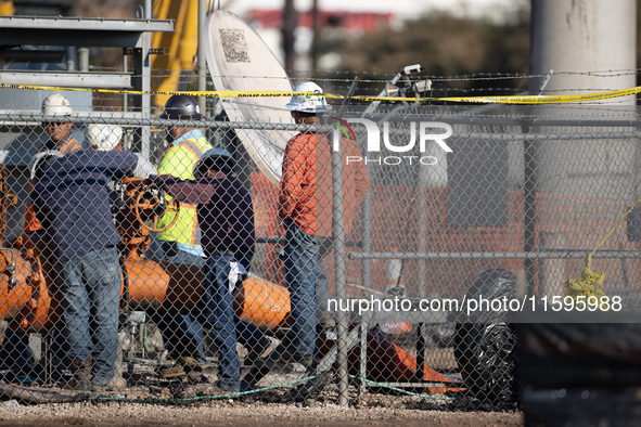 Workers repair a damaged liquefied gas pipeline following an explosion earlier in the week in La Porte, near Houston, Texas, on September 21...