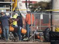 Workers repair a damaged liquefied gas pipeline following an explosion earlier in the week in La Porte, near Houston, Texas, on September 21...