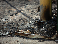 Burnt debris surrounds the site of the explosion in City, Country, on September 21, 2024. (