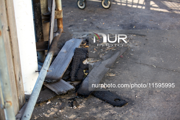 Burnt debris surrounds the site of the explosion in City, Country, on September 21, 2024. 