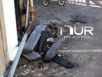 Burnt debris surrounds the site of the explosion in City, Country, on September 21, 2024. (