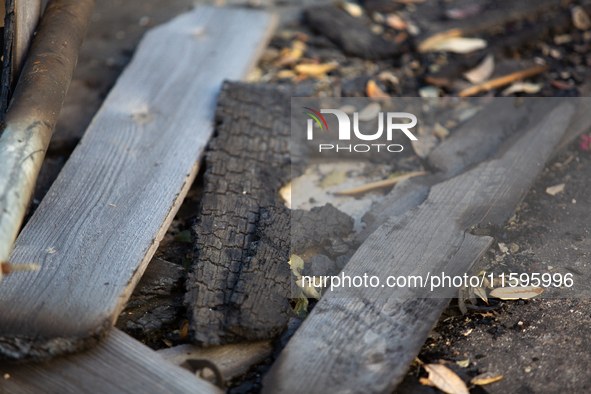 Burnt debris surrounds the site of the explosion in City, Country, on September 21, 2024. 