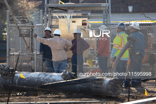 Near the site of the explosion in La Porte near Houston, Texas, on September 21, 2024, workers convene under what appears to be the melted i...