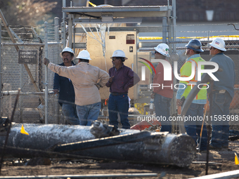 Near the site of the explosion in La Porte near Houston, Texas, on September 21, 2024, workers convene under what appears to be the melted i...