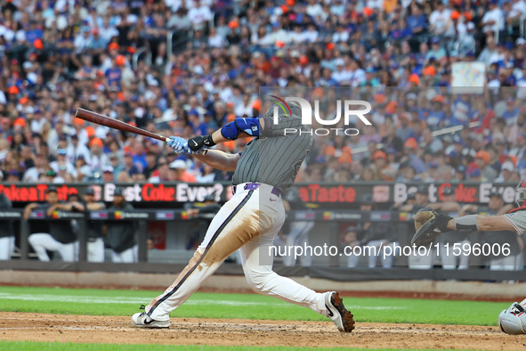 Pete Alonso #20 of the New York Mets singles to drive in a run during the eighth inning of the baseball game against the Philadelphia Philli...