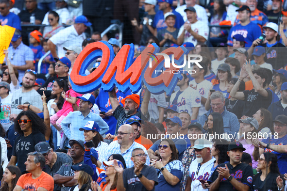 New York Mets fans hold up signs during the eighth inning of a baseball game between the Philadelphia Phillies and New York Mets at Citi Fie...