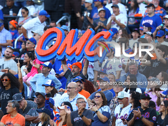 New York Mets fans hold up signs during the eighth inning of a baseball game between the Philadelphia Phillies and New York Mets at Citi Fie...