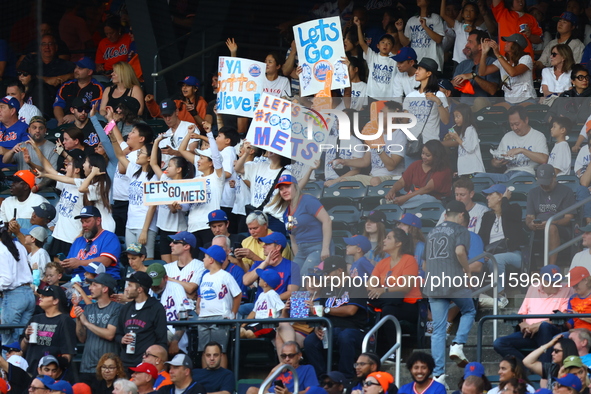 New York Mets fans hold up signs during the eighth inning of a baseball game between the Philadelphia Phillies and New York Mets at Citi Fie...