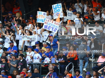 New York Mets fans hold up signs during the eighth inning of a baseball game between the Philadelphia Phillies and New York Mets at Citi Fie...