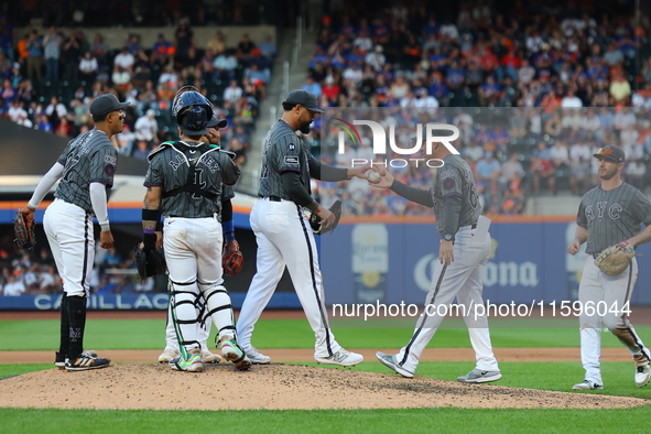 New York Mets manager Carlos Mendoza #64 removes starting pitcher Sean Manaea #59 from the game during the eighth inning of the baseball gam...