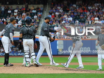 New York Mets manager Carlos Mendoza #64 removes starting pitcher Sean Manaea #59 from the game during the eighth inning of the baseball gam...