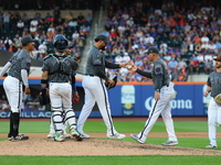 New York Mets manager Carlos Mendoza #64 removes starting pitcher Sean Manaea #59 from the game during the eighth inning of the baseball gam...