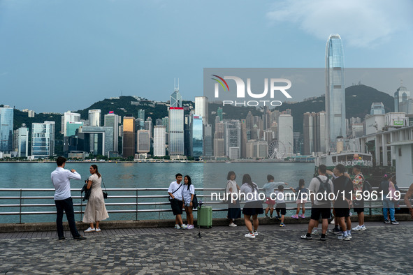 People at Tsim Sha Tsui Promenade look at the Hong Kong skyline in Hong Kong on September 22, 2024. 