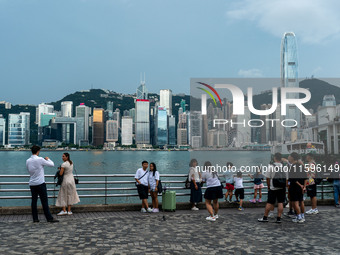 People at Tsim Sha Tsui Promenade look at the Hong Kong skyline in Hong Kong on September 22, 2024. (