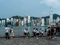 People at Tsim Sha Tsui Promenade look at the Hong Kong skyline in Hong Kong on September 22, 2024. (