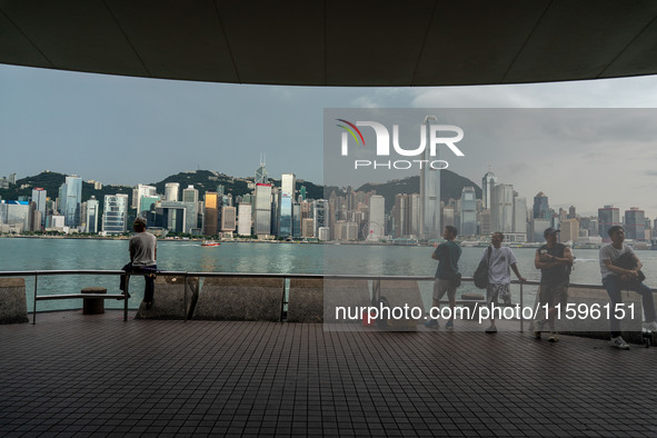 People at Tsim Sha Tsui Promenade look at the Hong Kong skyline in Hong Kong on September 22, 2024. 