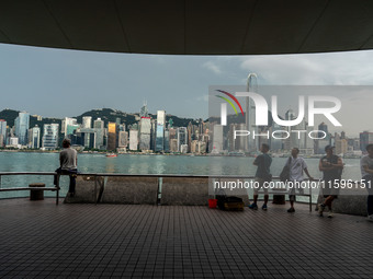 People at Tsim Sha Tsui Promenade look at the Hong Kong skyline in Hong Kong on September 22, 2024. (