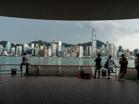 People at Tsim Sha Tsui Promenade look at the Hong Kong skyline in Hong Kong on September 22, 2024. (