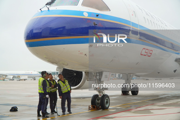 Airport ground staff check the C919 passenger plane of China Southern Airlines after it arrives at Hangzhou Xiaoshan International Airport f...