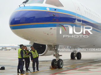 Airport ground staff check the C919 passenger plane of China Southern Airlines after it arrives at Hangzhou Xiaoshan International Airport f...