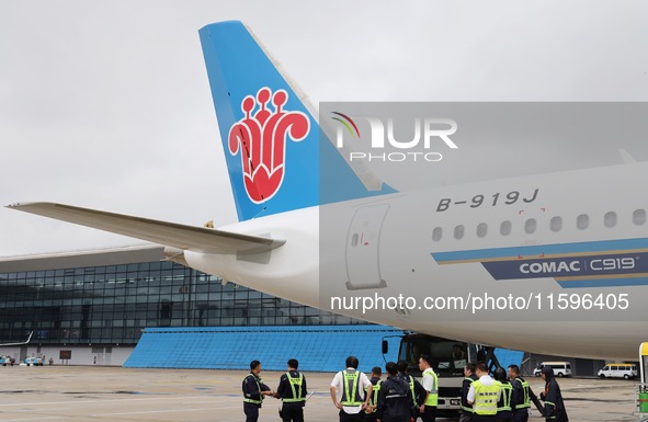 Airport ground staff check the C919 passenger plane of China Southern Airlines after it arrives at Hangzhou Xiaoshan International Airport f...