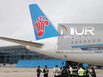 Airport ground staff check the C919 passenger plane of China Southern Airlines after it arrives at Hangzhou Xiaoshan International Airport f...