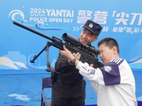 A child handles police firearms at the Open Day of a police camp in Yantai, China, on September 21, 2024. (