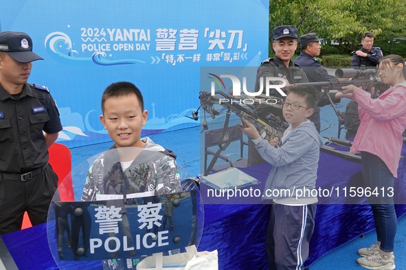 A child experiences police firearms and equipment at the Open Day of a police camp in Yantai, China, on September 21, 2024. 