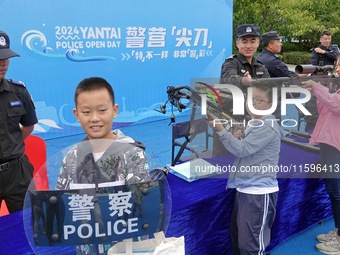 A child experiences police firearms and equipment at the Open Day of a police camp in Yantai, China, on September 21, 2024. (