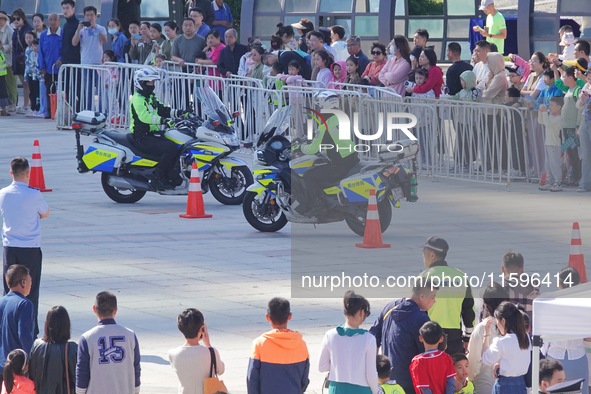 Traffic policemen demonstrate their driving skills on a police motorcycle during the Open Day of the police camp of Yantai Public Security B...