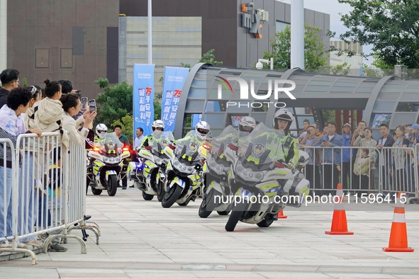 Traffic policemen demonstrate their driving skills on a police motorcycle during the Open Day of the police camp of Yantai Public Security B...