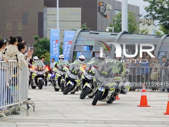 Traffic policemen demonstrate their driving skills on a police motorcycle during the Open Day of the police camp of Yantai Public Security B...