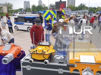 Citizens look at new intelligent police equipment at the Open Day of the police camp of Yantai Public Security Bureau in Yantai, China, on S...