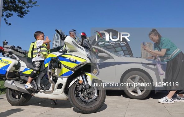 A child experiences a police motorcycle on the Open Day of a police camp in Yantai, China, on September 21, 2024. 