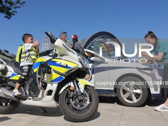 A child experiences a police motorcycle on the Open Day of a police camp in Yantai, China, on September 21, 2024. (