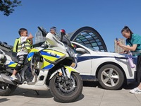 A child experiences a police motorcycle on the Open Day of a police camp in Yantai, China, on September 21, 2024. (