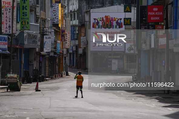 A laborer walks on the empty street in Colombo, Sri Lanka, on September 22, 2024. Curfew is imposed in Sri Lanka amid the counting of votes...