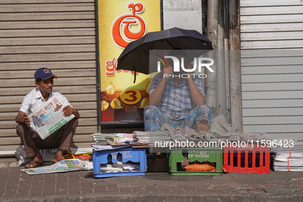 A street vendor takes a call from his mobile phone during the curfew period in Colombo, Sri Lanka, on September 22, 2024. Curfew is imposed...